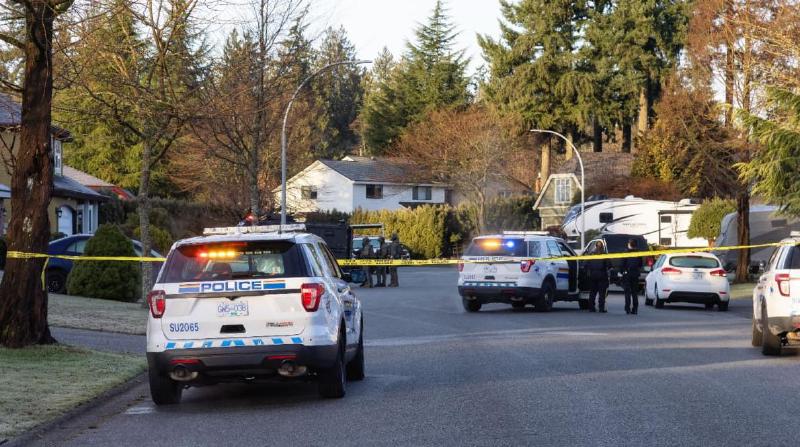 Politie met auto’s en een SWAT team bij een huis in de suburbs van British Columbia