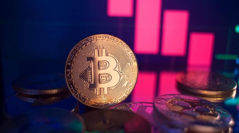 Gambar koin bitcoin (BTC) dengan grafik harga merah yang menurun di latar belakang